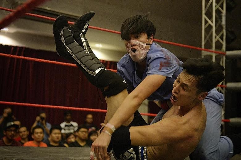 Dr Gore (Caleb Tan in blue doctor's scrubs) tackles opponent Mister Consistency (who wants to be known only by his initials,MK), 25, in a dramatic fashion with both displaying exaggerated expressions of pain, much to the delight of the audience.