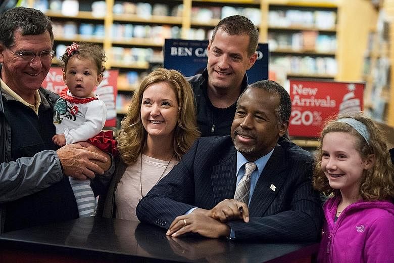The latest poll puts retired neurosurgeon Ben Carson (wearing a tie), seen here with supporters last Saturday during a book tour, ahead of billionaire Donald Trump in the battle to be the Republican presidential candidate.
