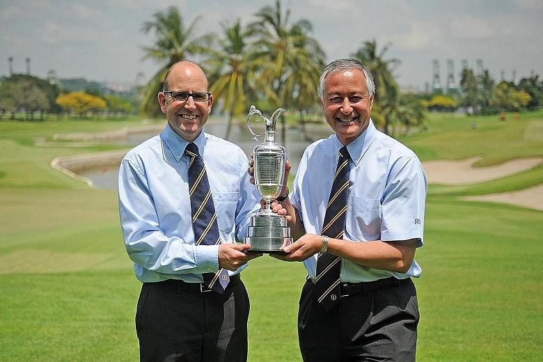 Grant Moir (far left), the R&A's director (rules of golf) and David Bonsall, the chairman of the organisation's rules of golf committee, holding the British Open trophy.
