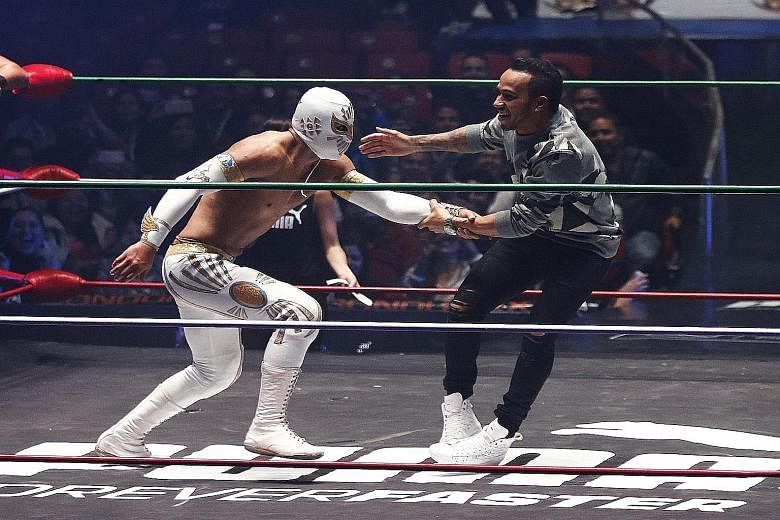 Lewis Hamilton (right) gets to grips with a wrestler at the Arena Coliseo in Mexico City on Wednesday, to promote the Mexican Grand Prix on Sunday.