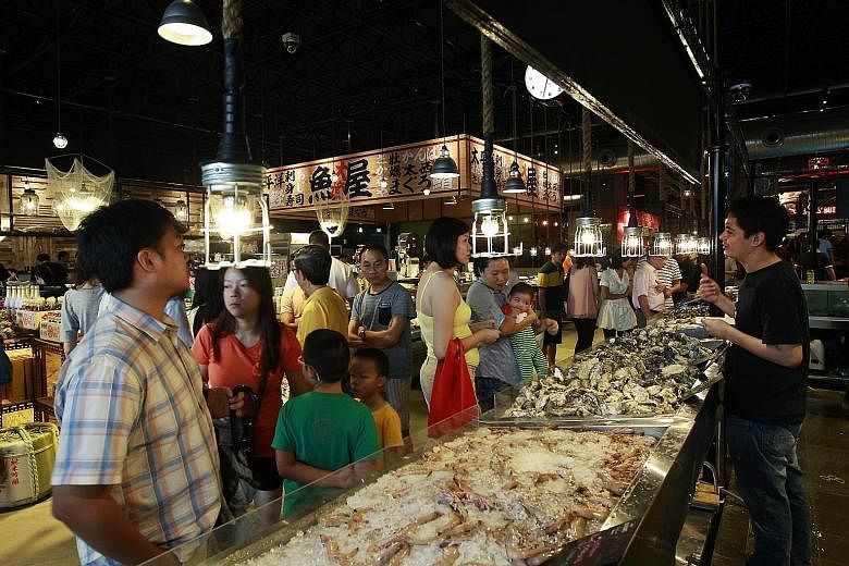 Customers checking out fresh seafood on sale at one of the stalls in PasarBella, a market located at The Grandstand.