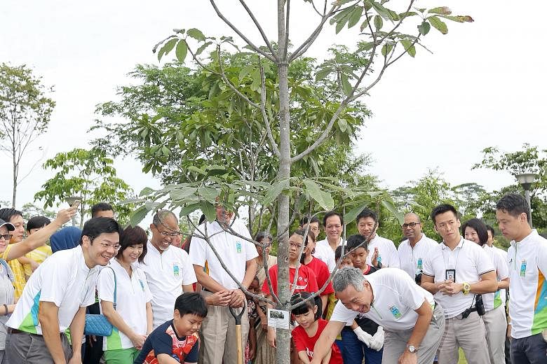 Prime Minister Lee Hsien Loong plants a jelutong tree at the Punggol Waterway Park. With him are (from left) Minister for National Development Lawrence Wong; Senior Minister of State for the Environment and Water Resources Amy Khor; Minister for the 