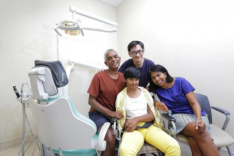 Dr Tay Chong Meng with his patient Malene Karunanidhi (centre), her father Karunanidhi and mother Pushpa Karuppiah. Dr Tay is the first of four special- needs dentists in Singapore trained to treat patients like Ms Malene, who has Rett syndrome.
