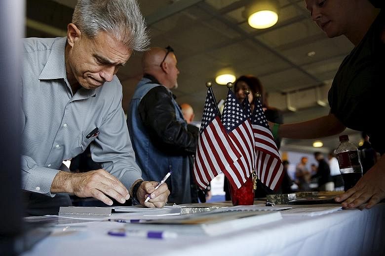 A job seeker filling out papers at a military job fair in San Francisco. All eyes are now on Friday's release of US employment figures, a major indicator used by the Fed to gauge the state of the US economy.