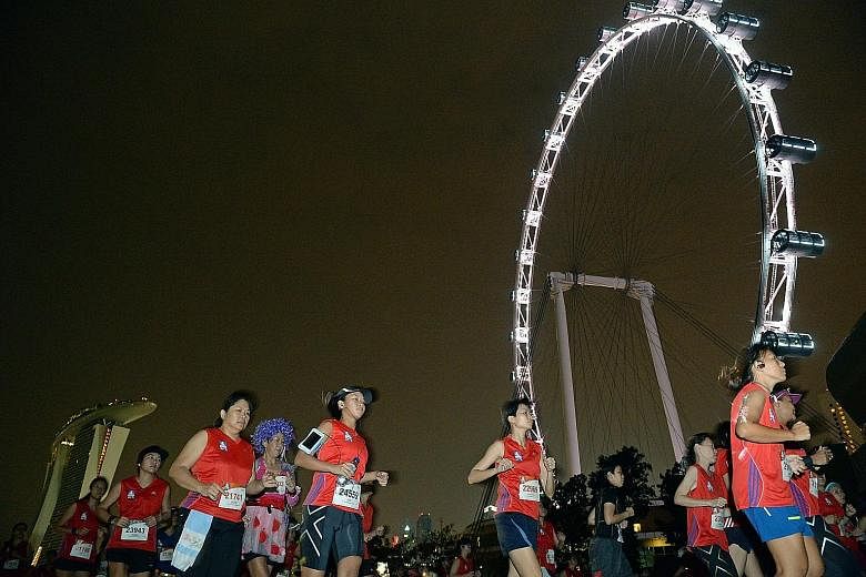 Participants running past the Singapore Flyer just after the flag-off for the Great Eastern Women's Run 21.1km event, which was won by North Korean Kim Ji Hyang.