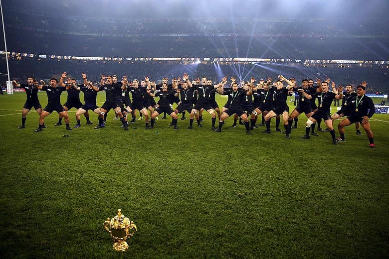 New Zealand perform the haka with the Webb Ellis trophy after winning the World Cup for a record third time on Saturday. They are the first team to retain the trophy.