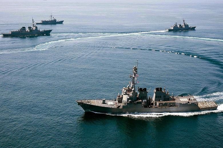 A handout photo released by the US Navy dated May 25 of the guided-missile destroyer USS Lassen (foreground) conducting a trilateral naval exercise with the Turkish and South Korean navies.