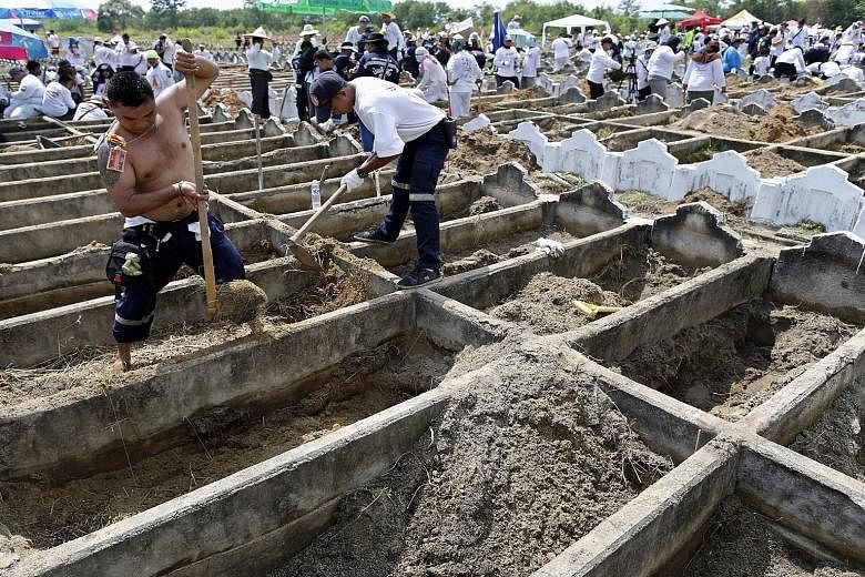 Volunteers digging up unidentified bodies during a mass exhumation at Poh Teck Tung Foundation Cemetery in Samut Sakhon province, Thailand, on Friday. The remains of 3,890 people have been retrieved and they will be cleansed before they are stored in