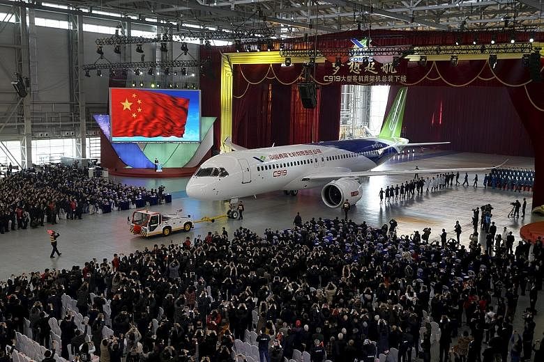 Comac unveiling its first C-919 passenger jet during a news conference at the company's factory in Shanghai yesterday. The plane represents China's efforts to reduce dependence on Airbus and Boeing.