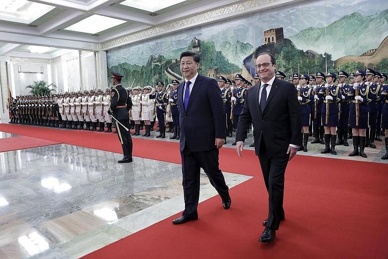 Chinese President Xi Jinping accompanying his French counterpart Francois Hollande (right) as they inspected guards of honour during a welcoming ceremony at the Great Hall of the People in Beijing yesterday.