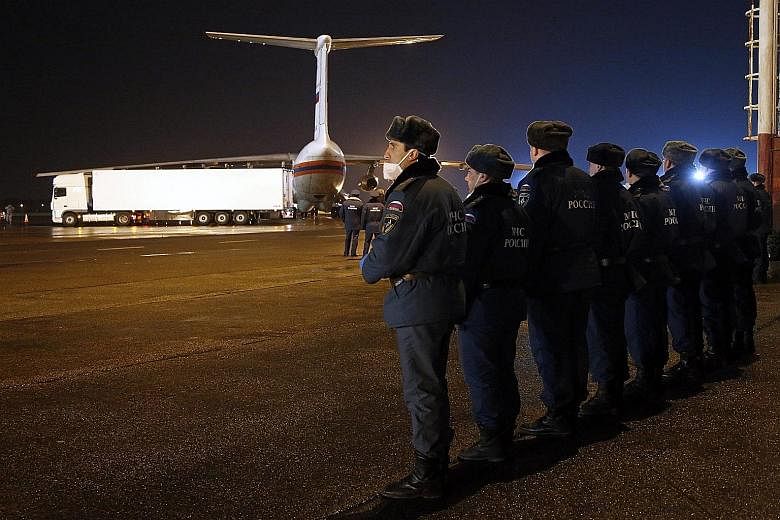 Russian Emergency Situations Ministry employees waiting to unload the bodies of the air crash victims from a ministry airplane in St Petersburg yesterday. St Petersburg deputy governor Igor Albin told news agencies that Russian experts had already st