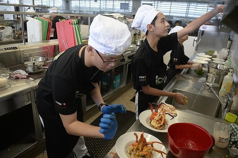 St. Patrick's School students Ian Wee (left) and Fahd Shah Mohammad Nizam, both 15, hard at work at Republic Polytechnic's Oliva Training Restaurant and Kitchen during the annual iChef Challenge last month. Acting Education Minister Ong Ye Kung yeste