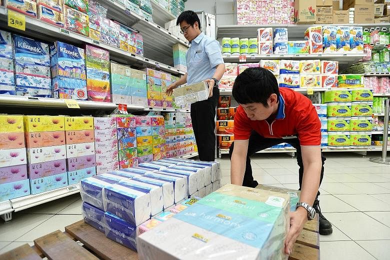 FairPrice employees William Lim (left) and Ong Wei Kiat removing APP products from the supermarket chain's nex outlet last month. APP has been accused of having fires on its concessions. Firefighters putting out a blaze in Banyuasin regency, South Su