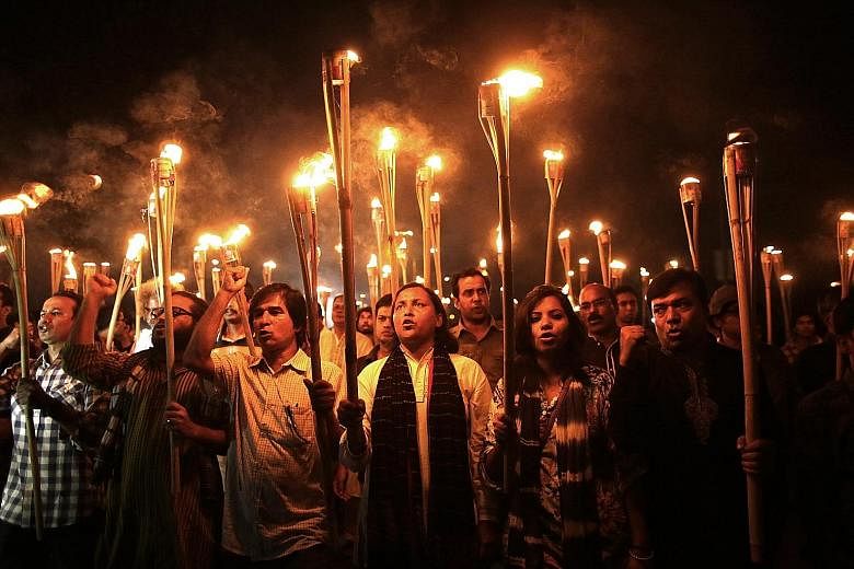 Cultural activists, writers and members of the secular movement Ganajagaran Mancha at a torchlit procession protesting against the killing and attacks on a publisher and bloggers in Dhaka, Bangladesh, on Monday. The group also called for a half-day c