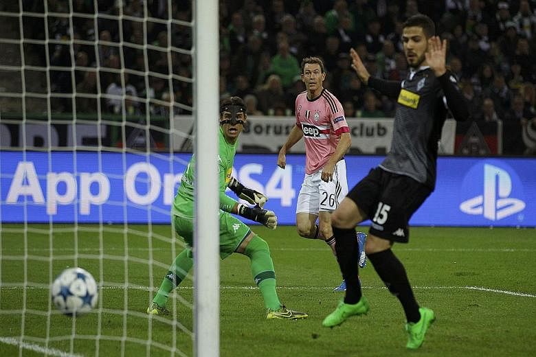 Stephan Lichtsteiner (in pink) sends the ball past hosts Moenchengladbach's goalie Yann Sommer (left) for his first Champions League goal.
