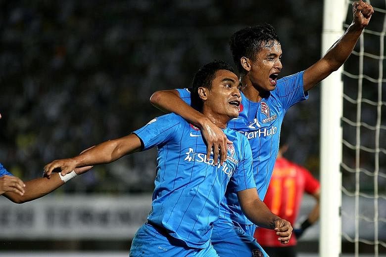 LionsXII substitute Sufian Anuar (left) and Safuwan Baharudin celebrating his equaliser after just coming on for Khairul Amri. Torrential rain and a waterlogged pitch halted play for half an hour just past the hour mark.