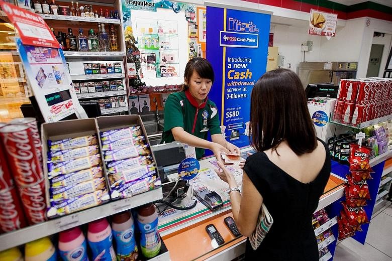A customer withdrawing money at a 7-Eleven store in a file photo from 2013, when the service first began. Last year, Guardian Health & Beauty and Sheng Siong stores came on board. Now, DBS has expanded its POSB Cash-Point service to Cold Storage, Mar