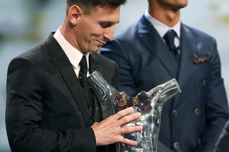 Barcelona's Lionel Messi (left) receiving his trophy after being named Uefa's best player in Europe for the 2014-2015 season on Aug 27. He had beaten Cristiano Ronaldo (right) and Luis Suarez to the honour.