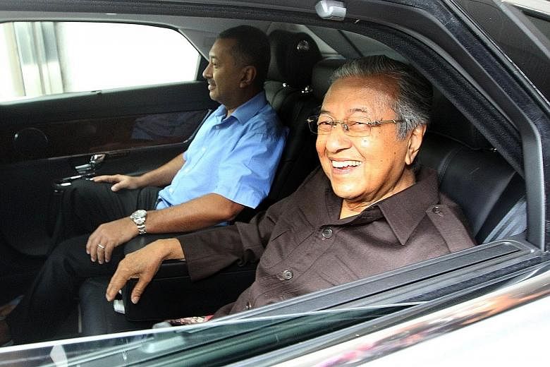 Dr Mahathir Mohamad leaving his office yesterday with his son Mokhzani Mahathir. No sitting or previous Malaysian prime minister has ever been questioned by the police.