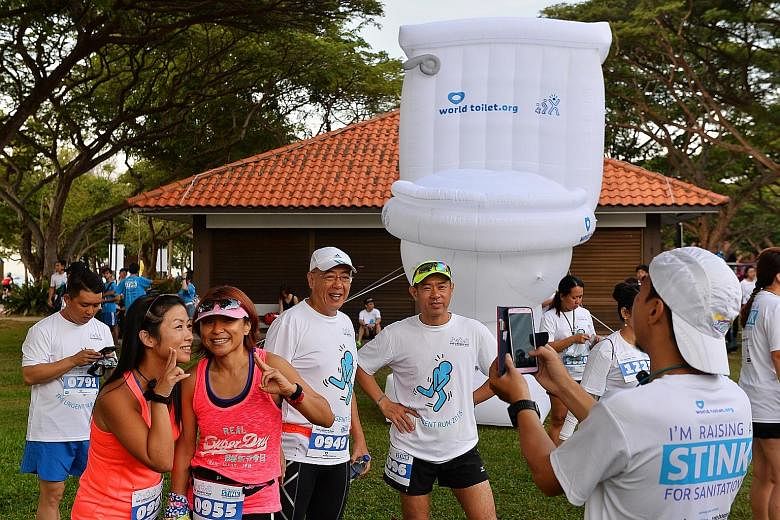 Runners posing for pictures with a giant blow-up toilet at The Urgent Run at East Coast Park yesterday. About 1,000 people took part this year, up from 350 at last year's inaugural event.