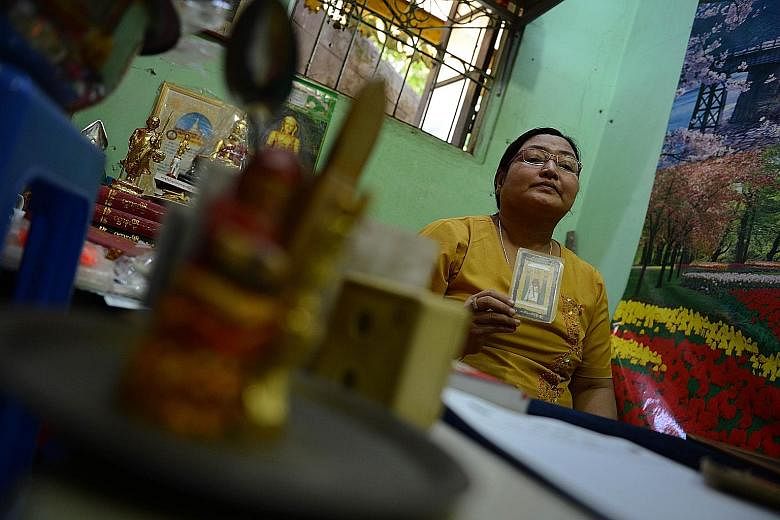 Myanmar fortune teller Hnin Ohn Mar Yee with a tarot card at her booth in the Shwedagon Pagoda compound in Yangon.
