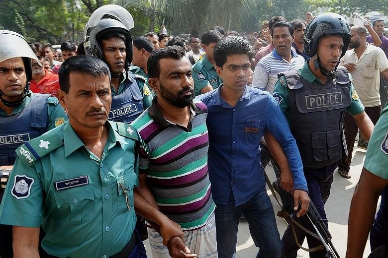 Bangladesh police escorting a suspect (centre) in the high-profile murder case involving the lynching of a 13-year-old boy at a court in Khulna yesterday.