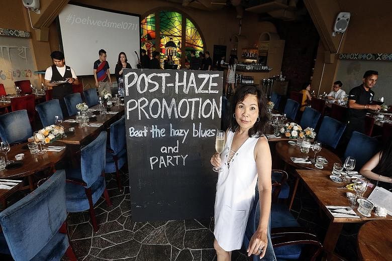 Ms Belinda Lim, co-owner of The Wine Company, says the restaurant is waiving the $8,000 minimum spend to hold functions at its three outlets as it tries to earn back what it lost from cancellations during the haze.