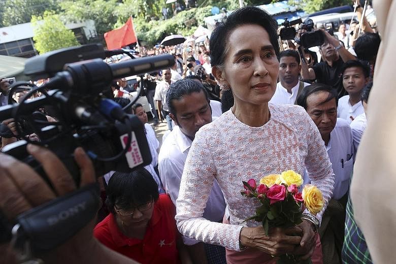 Ms Aung San Suu Kyi arriving at the NLD headquarters in Yangon yesterday, where supporters were celebrating in expectation of a big win.