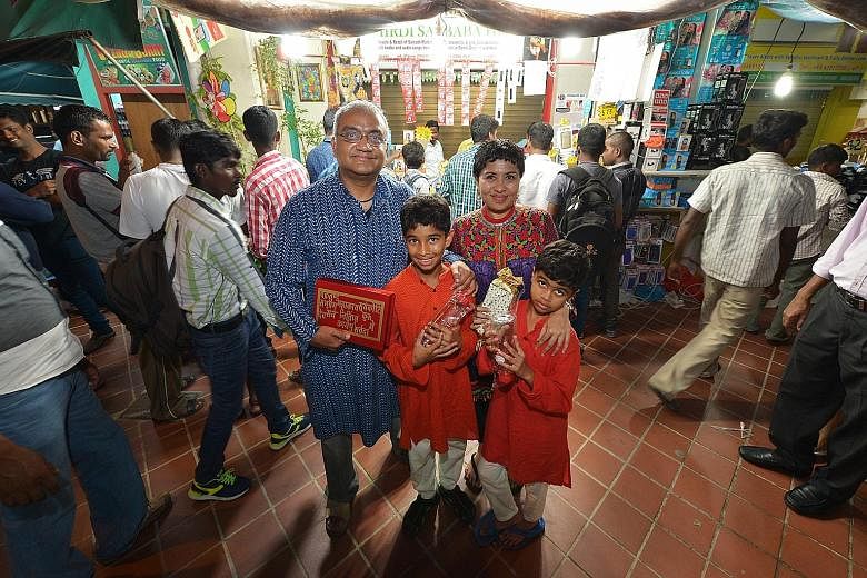Ms Dipa, her husband Vish Srinivasan, 48, elder son Vihaan, 10, and younger son Kairav, eight, in Little India, with some of the items they are giving out to migrant workers this Deepavali.