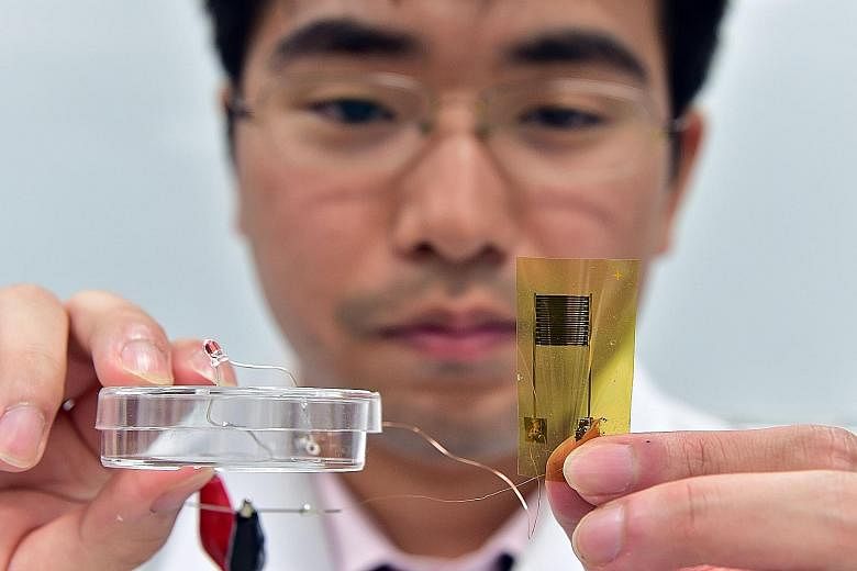 University of Tokyo researcher Tomoyuki Yokota showing an ultra-thin flexible thermal sensor on a plastic film at the laboratory of Professor Takao Someya, who heads a team that developed it. The thermal sensor, whose electronic circuit is just 15 mi