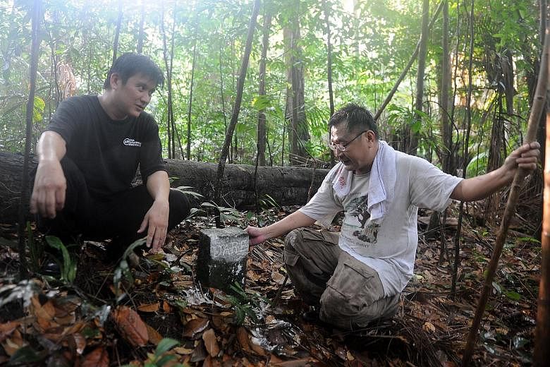 Mr Charles Goh (far left), 47, and Mr Raymond Goh, 51, who are researching Bukit Brown and its vicinity, discovered the significance of two markers, which pieced together the story of Mr George Mildmay Dare and Mr Seah Eu Chin, who were among the fir
