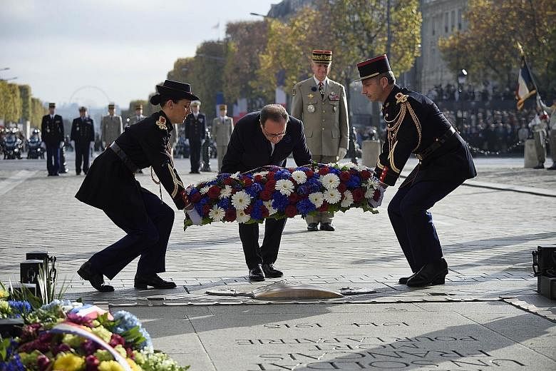 French President Francois Hollande (centre) laying a wreath at the Tomb of the Unknown soldier during Armistice Day ceremonies, which mark the 97th anniversary of the end of World War I, yesterday at the Arc de Triomphe monument in Paris. Officials a
