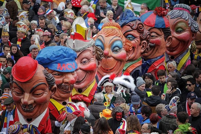 The Schwellkoepp (big heads made of papier mache) from the Mainz Carnival Association moving through the crowd in Mainz, Germany. The carnival season starts each year on Nov 11 at 11.11am and ends on Ash Wednesday of the following year. It is one of 