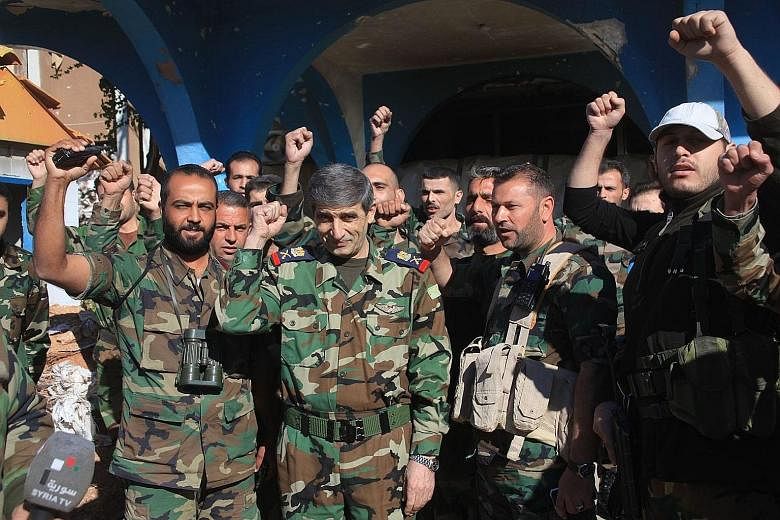 The Syrian army's Major-General Mounzer Zamam (centre) celebrating among soldiers at the Kweyris military airbase, in the northern Syrian province of Aleppo, yesterday.