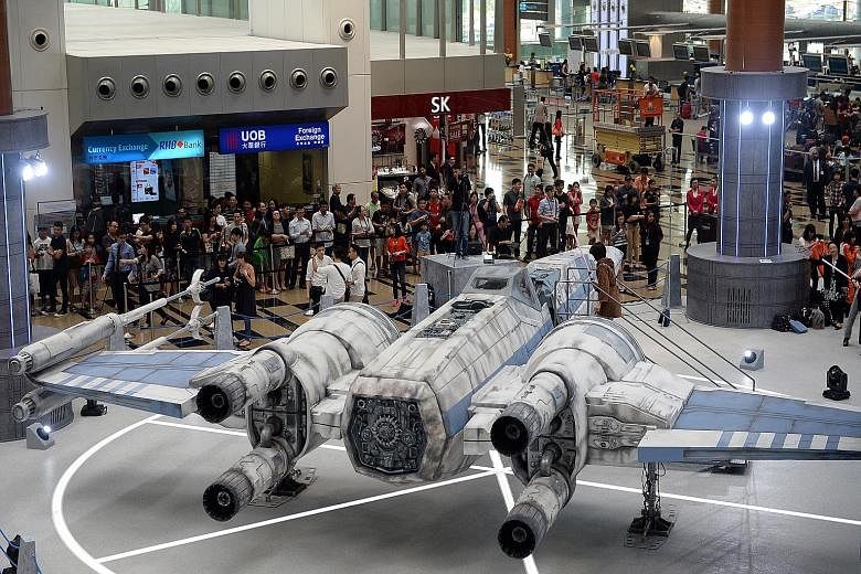 Star Wars fans having a field day at Changi Airport where they came face to face with Stormtroopers (above) and a scale model of the TIE Fighter (top). Singapore is the first Asian stop outside of Japan for the Star Wars-themed All Nippon Airways pla