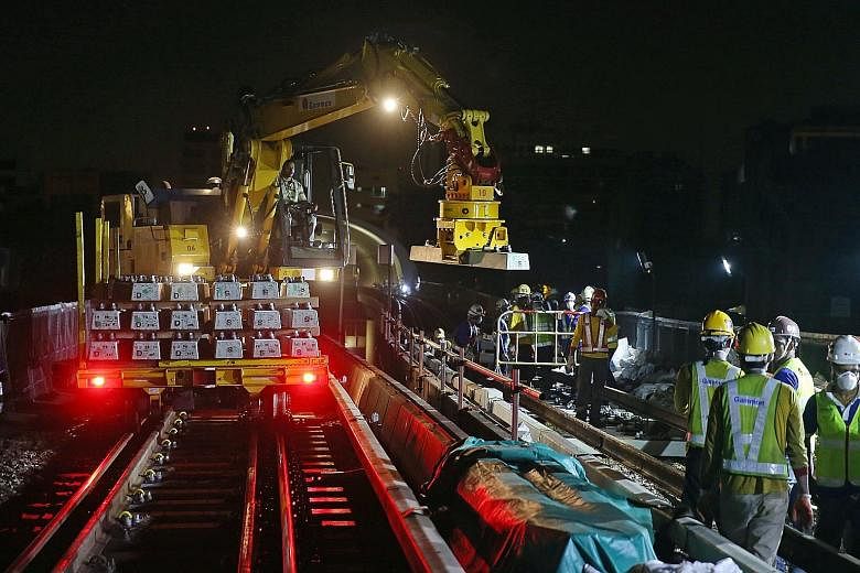 A road-rail vehicle placing a new concrete sleeper onto the track near Aljunied MRT station. Train services on stretches of the EWL will end 30 minutes earlier, with nine stations between Bugis and Tanah Merah being the first to be affected.