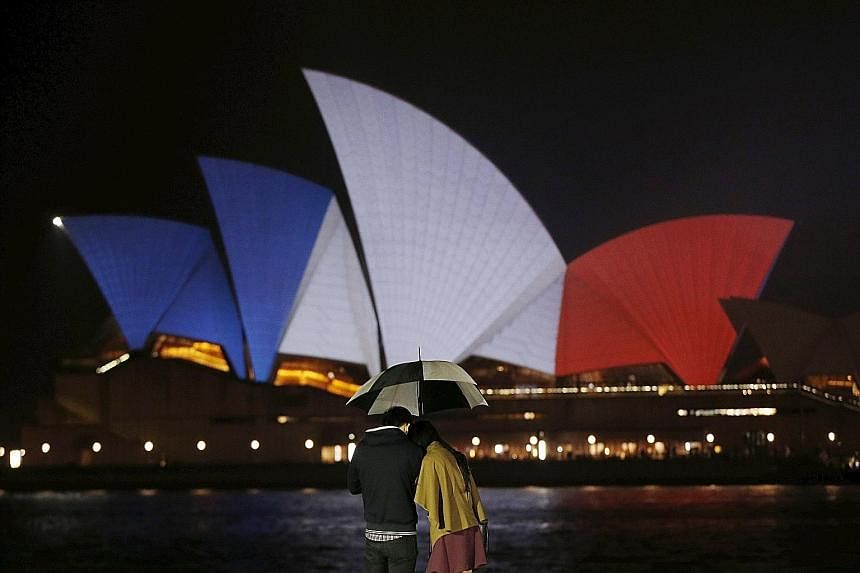 The blue, white and red colours of France's national flag were projected onto the Sydney Opera House yesterday, in a show of Australian solidarity with the French. It was one of several global landmarks similarly lit up. Rescuers evacuating people fo