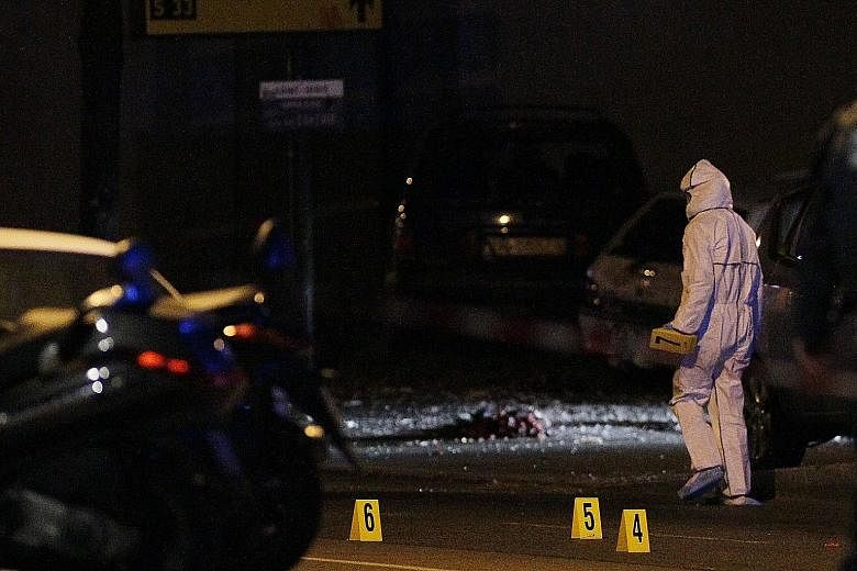 A forensic investigator at the scene of the attack near the Stade de France in Saint Denis, suburban Paris, on Friday. Singaporeans staying near the attack sites called the experience a nightmare.