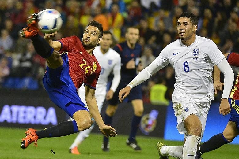 Spain's Mario Gaspar escapes the attention of England defender Chris Smalling (far right) to score with a spinning volley during their friendly match. The Three Lions slumped to their first defeat after 10 straight wins in their Euro 2016 qualifying 