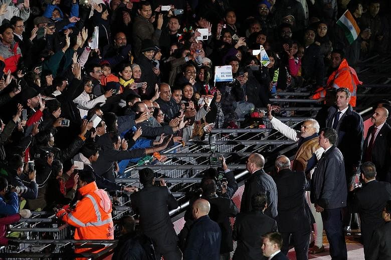 Mr Narendra Modi waving to the crowd as he walked around London's Wembley stadium after addressing a welcome rally in his honour last Friday.