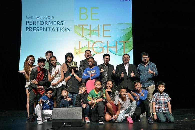 (Back row, from right) Guitarist Regi Leo, music director Jeremy Monteiro, The Business Times editor Alvin Tay, creative director Jeremiah Choy and Straits Times Schools programme editor Serene Goh posing with ChildAid performers at the Mastercard Th