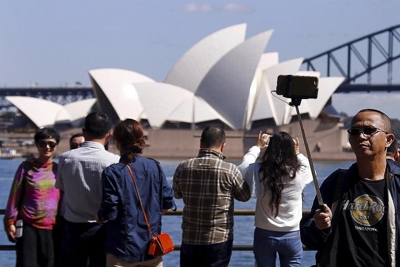 Chinese tourists taking pictures in front of the Sydney Opera House. The number of Chinese tourists overtook those from New Zealand in September.