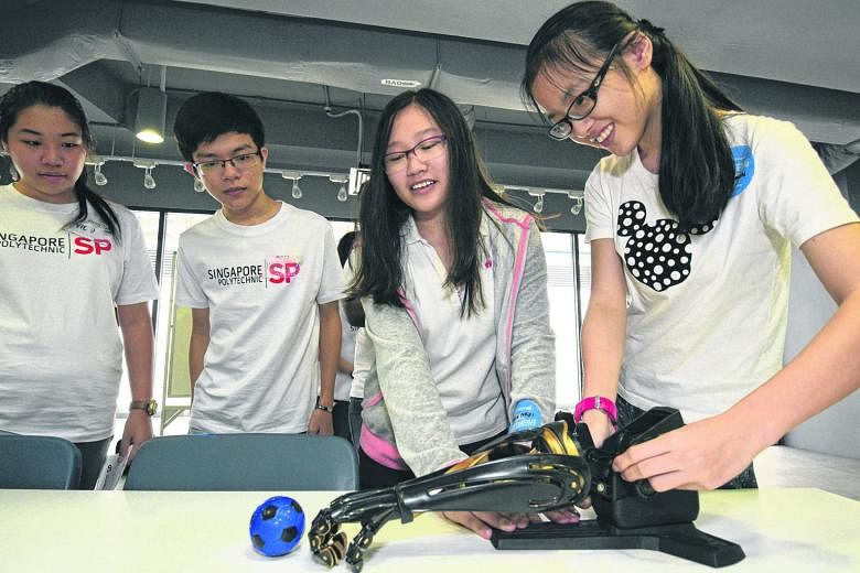 Secondary school students getting hands-on experience with a robot during a one-day programme jointly organised by Singapore Polytechnic's School of Mechanical and Aeronautical Engineering, and School of Electrical and Electronic Engineering.