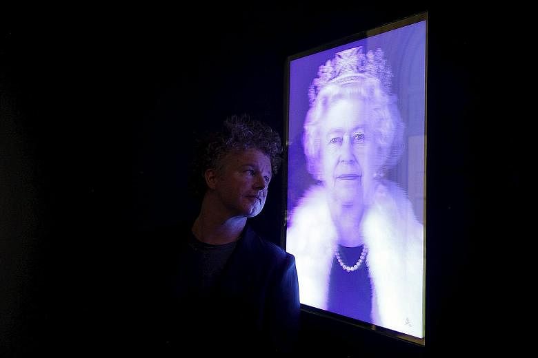 Artist Chris Levine posing with his lenticular image of Britain's Queen Elizabeth II at the National Portrait Gallery in London.