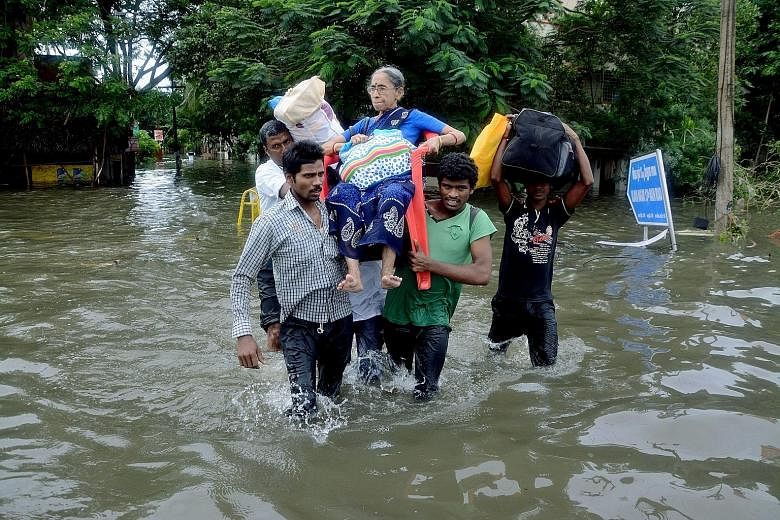 Residents carrying an elderly woman who was trapped in her home due to flooding in Chennai on Monday. India's annual monsoon season lasts from June to September.