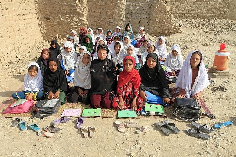 Teacher Mahajera Armani and her class of girls at their open study area, founded by the Bangladesh Rural Advancement Committee, outside Jalalabad, in Afghanistan.