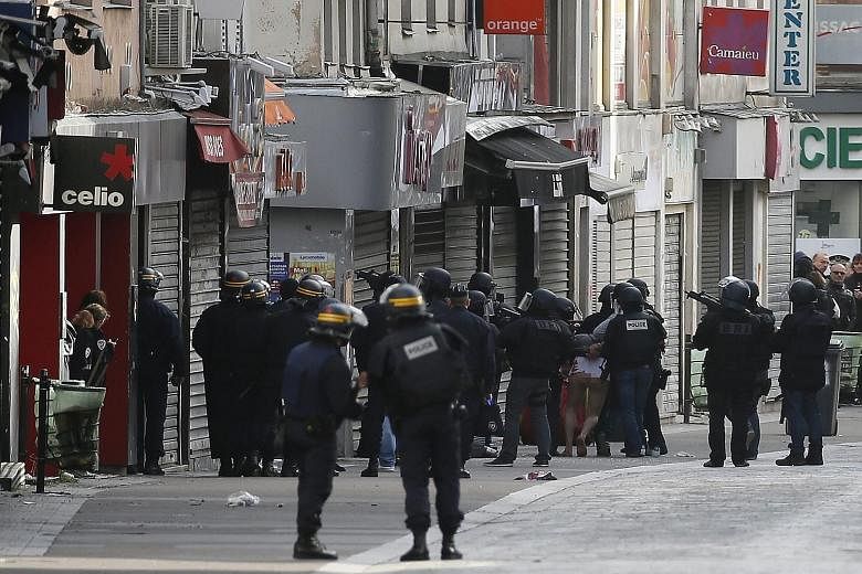 A man being arrested by police officers at the site where a raid took place in the northern Paris suburb of Saint-Denis yesterday. The raid came after footage from the scene of one of the Paris attacks revealed a ninth suspect may have taken part.