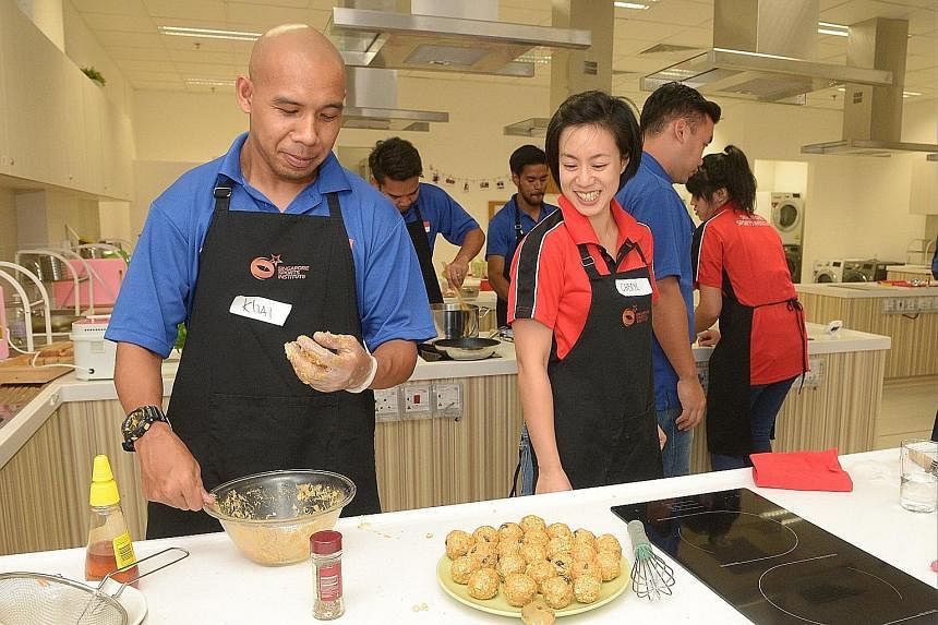 Singapore cerebral palsy football captain Khairul Anwar captain making muesli balls under the guidance of Singapore Sports Institute associate sport dietitian Cheryl Teo last night. The workshop was the second conducted on eating for recovery.