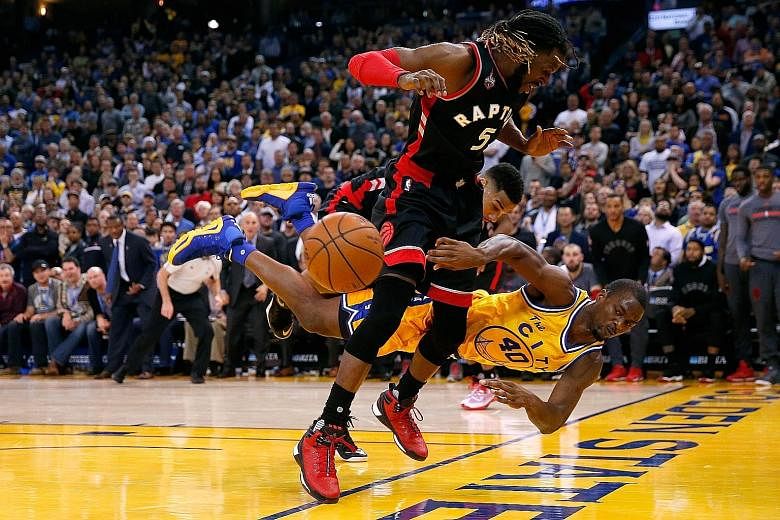 Harrison Barnes (No. 40) of the Golden State Warriors diving to save the ball from going out of bounds, as DeMarre Carroll of the Toronto Raptors looks on. The Warriors won 115-110 at home on Tuesday.