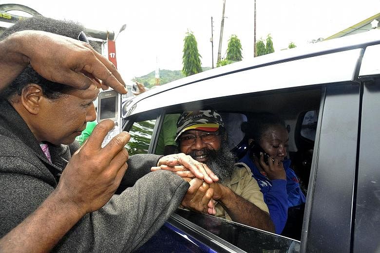 Papuan pro- independence activist Filep Karma (in vehicle) greeting his supporters after being released from prison in Abepura, Papua province, on Thursday. The high-profile Papuan separatist leader was released from prison after more than a decade b